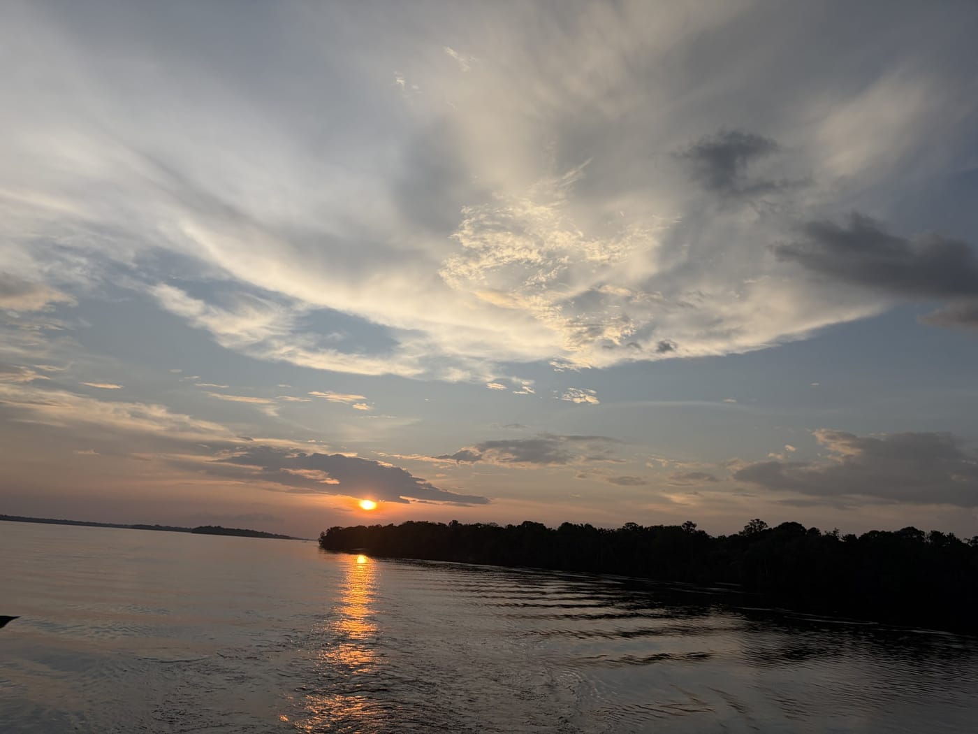 Pôr do sol sobre o rio, com o reflexo dourado na água