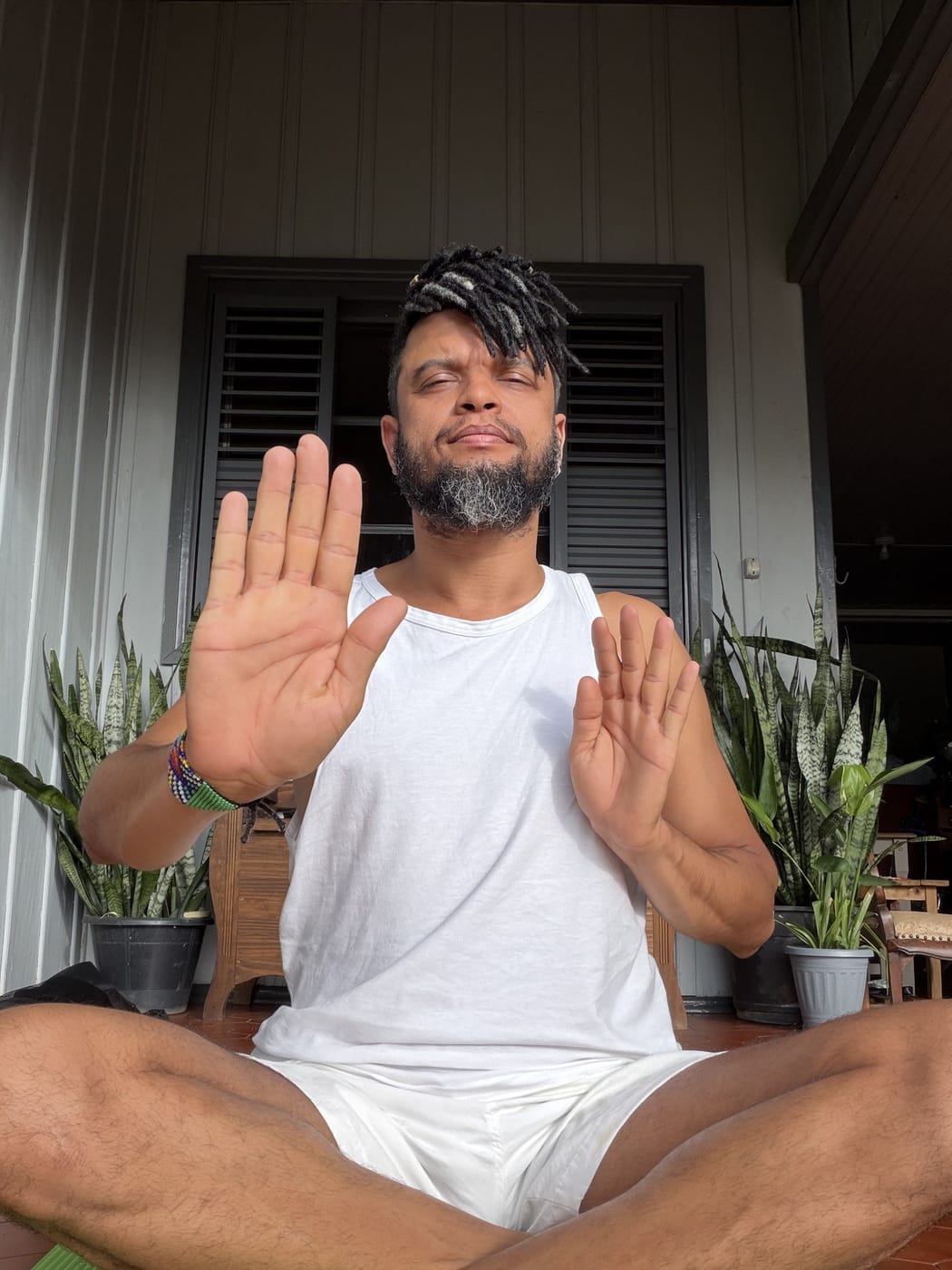 Keâ Costa sentado em meditação, com as palmas das mãos voltadas para a frente