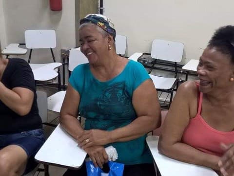 Mulheres sorrindo, sentadas em roda