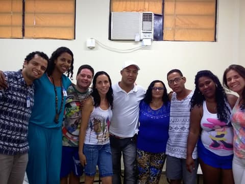 Grupo reunido em sala, com profissionais de saúde